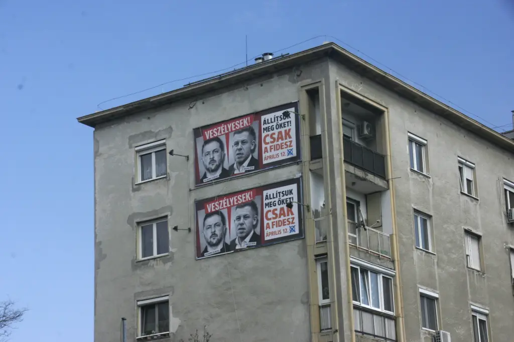 Fidesz Wahlplakat zur Wahl am 12. April, das Zelensky und Magyar in dunkler Bearbeitung und feindlichem Schriftzug