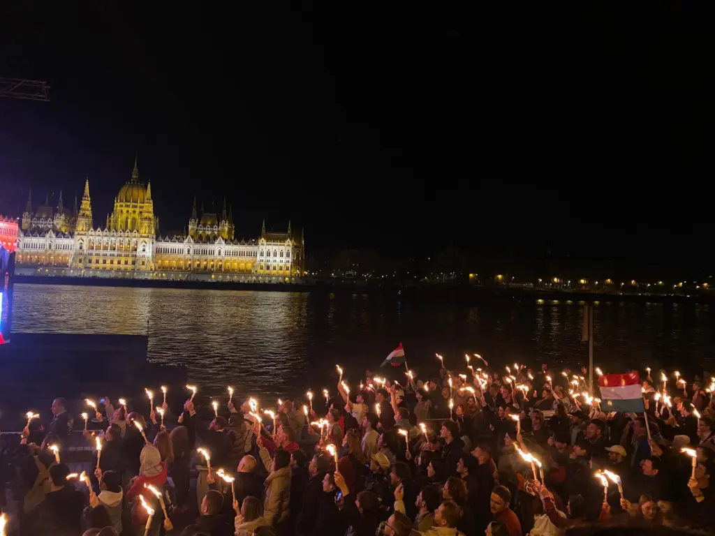 22:40, Péter Magyars Wahlsieg steht bereits fest: Vor der Live- Übertragung feiert die Menge mit unzähligen Fackeln.
