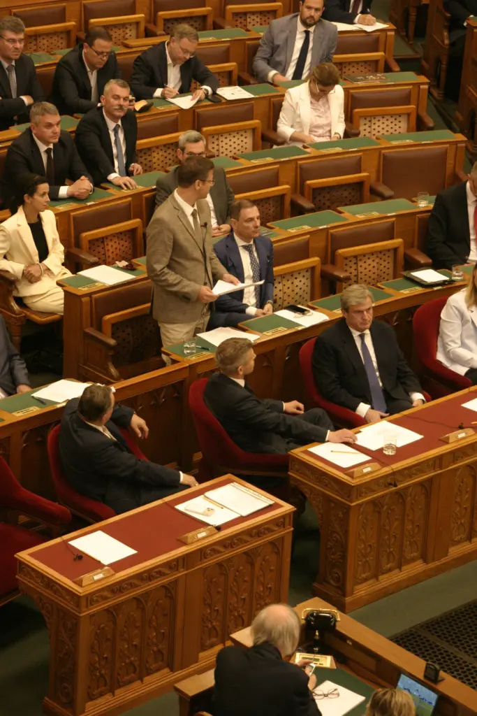 Am zweiten Tag der Nationalversammlung nimmt Ministerpräsident Péter Magyar während eines Redebeitrags des Fidesz Politikers Gergely Gulyás einen der Minister-Sitze vor dem Redner ein, was bei der TISZA Fraktion für Belustigung sorgt.