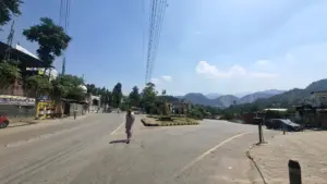 Photo: An elderly resident walks down an empty central roadway in Muzaffarabad during midday heat, amid a region-wide commercial shutdown and traffic suspension.