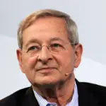 Nádas Péter inmitten seiner Bücher in einer ungarischen Bibliothek