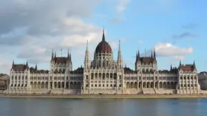 Blick über die Donau auf das ungarische Parlamentsgebäude in Budapest mit seiner markanten Kuppel und den Türmen.