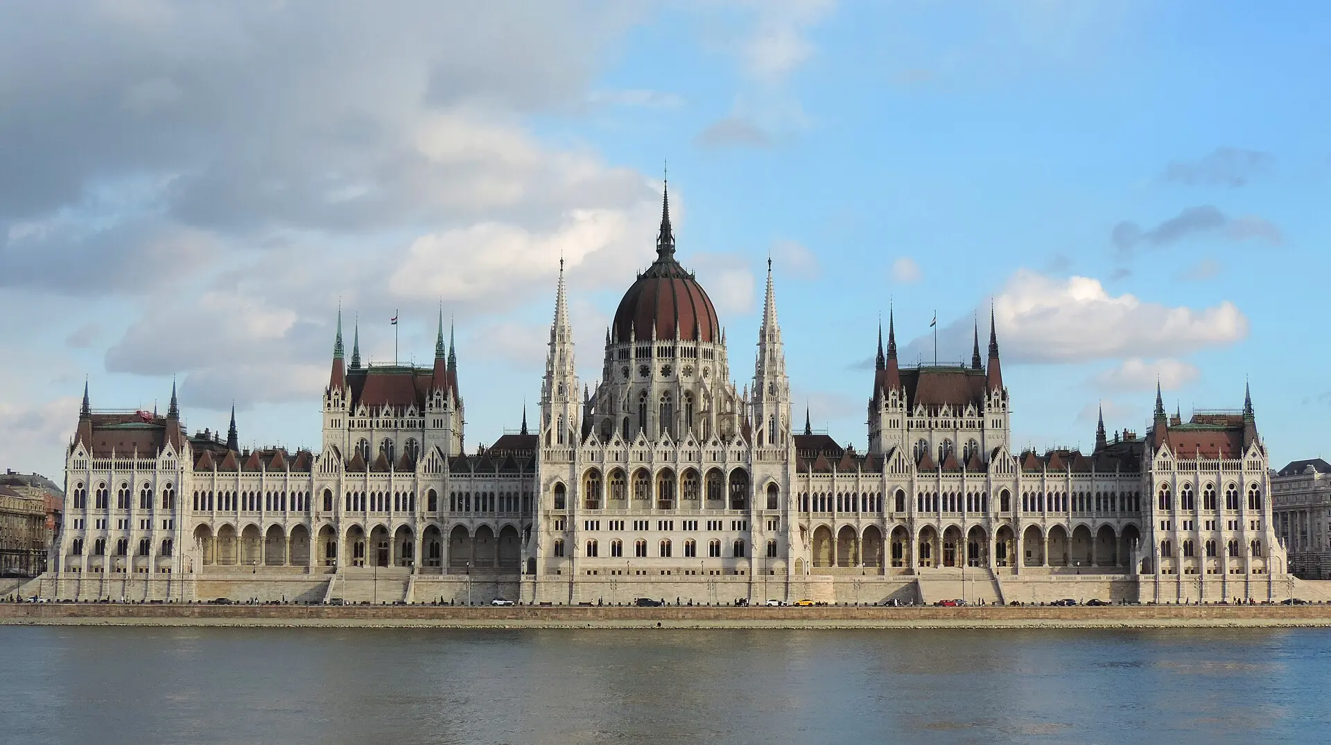 Blick über die Donau auf das ungarische Parlamentsgebäude in Budapest mit seiner markanten Kuppel und den Türmen.