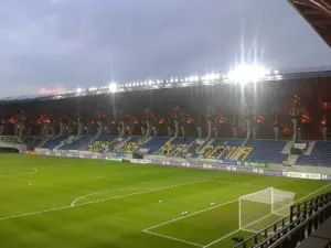 Blick in die leere Pancho Arena in Felcsút mit überdachten Tribünen und Fußballfeld.